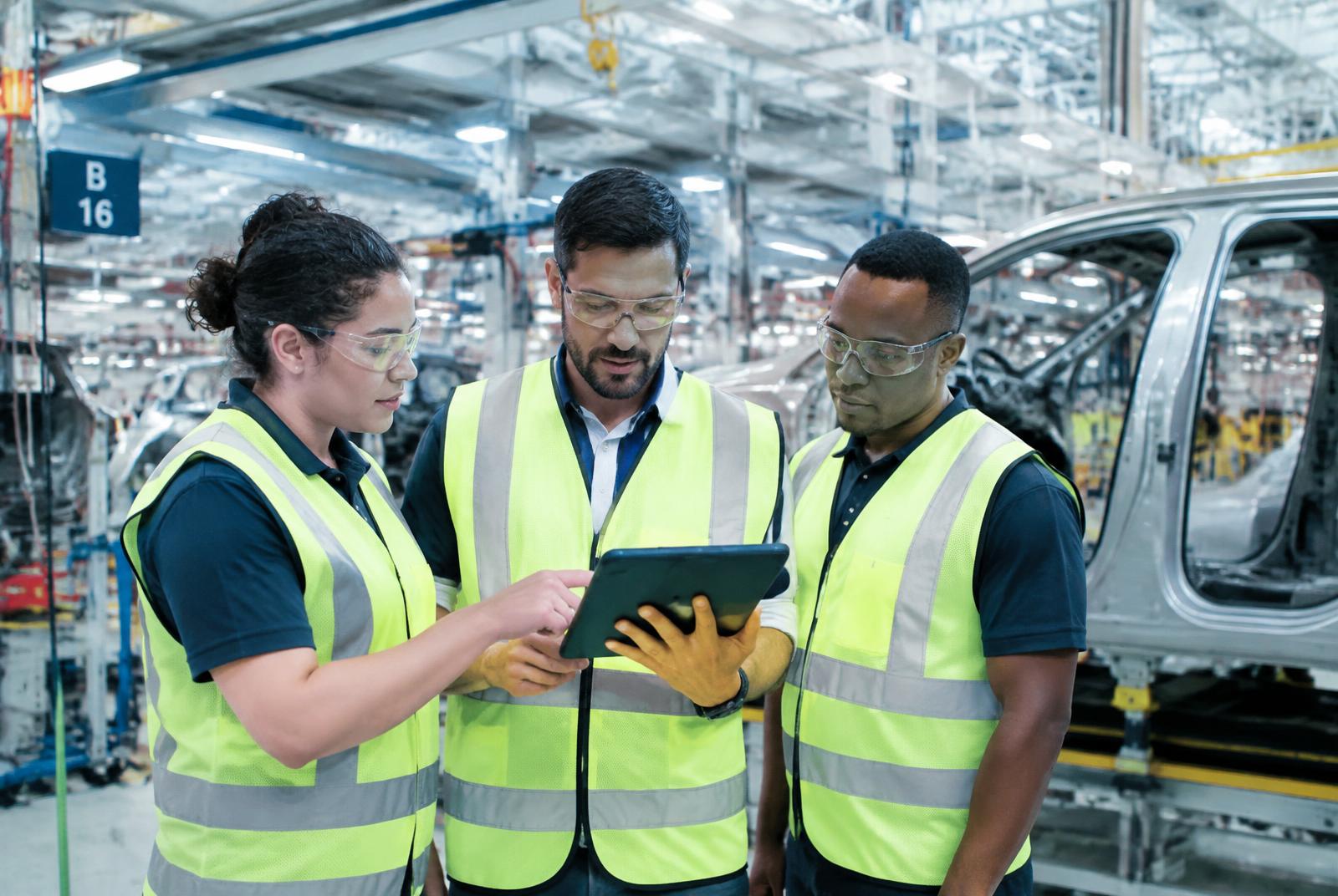Ingenieros en una planta automotriz en Brasil revisando datos en una tablet
